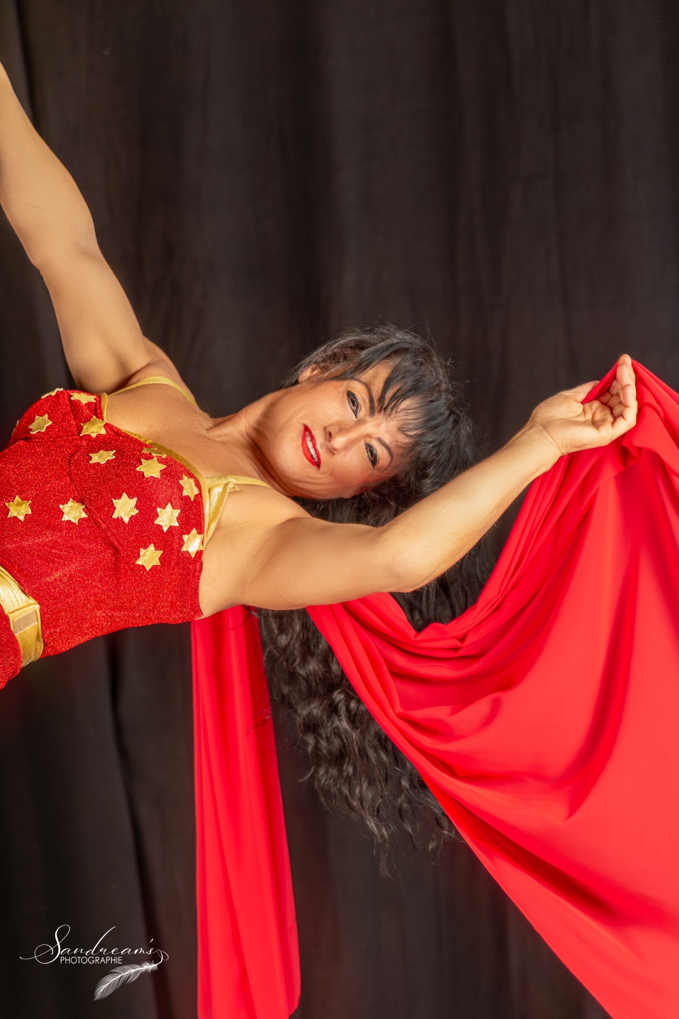 Isabella en costume rouge et or avec son tissu rouge